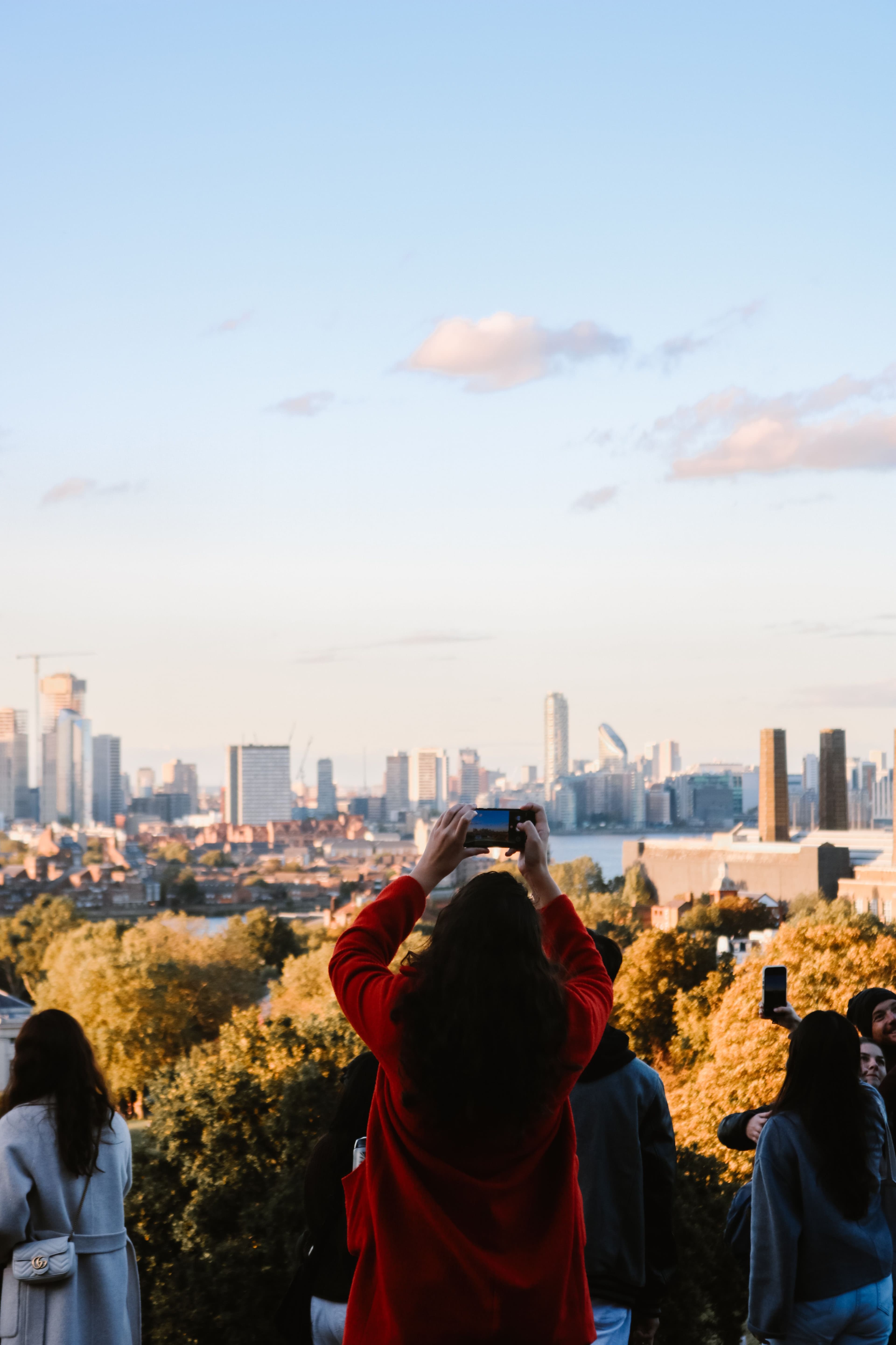 Traveler photographing a city skyline at golden hour