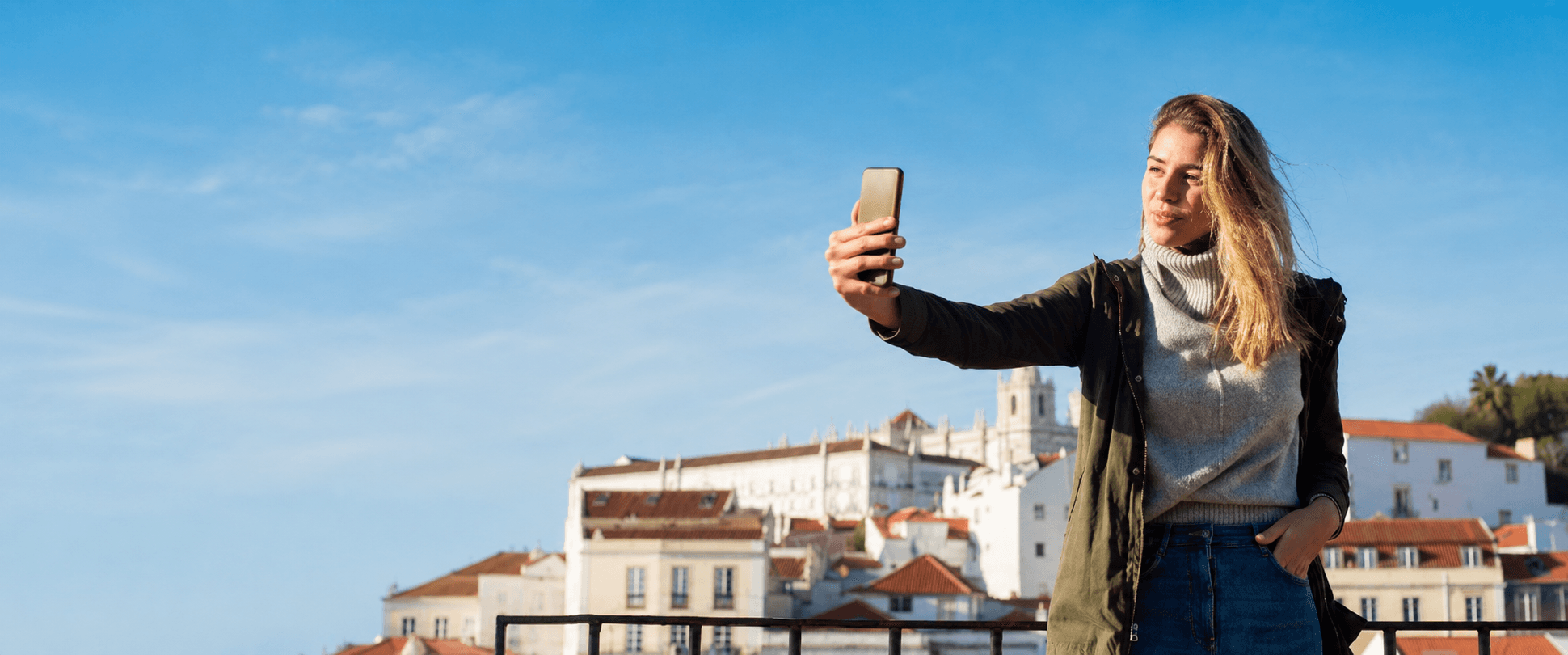 Traveler taking a selfie with a European old-town skyline behind her